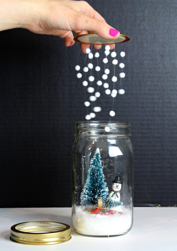 decoration de noel à fabriquer soi-même avec des bocaux en verre recyclés et des figurines de noël, un globe de neige diy sans eau à fausse neige suspendue au couvercle 