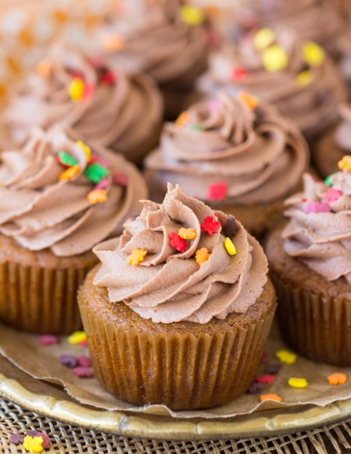 exemple de cupcakes à la citrouille avec glacage au chocolat nutella et beurre, décoration de petites étoiles sucrées comestibles