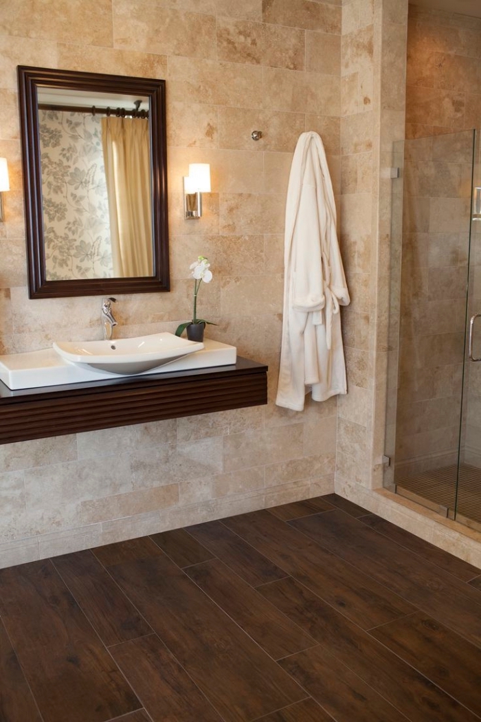 revetement salle de bain, cabine de douche en verre et carrelage beige avec plancher en bois foncé