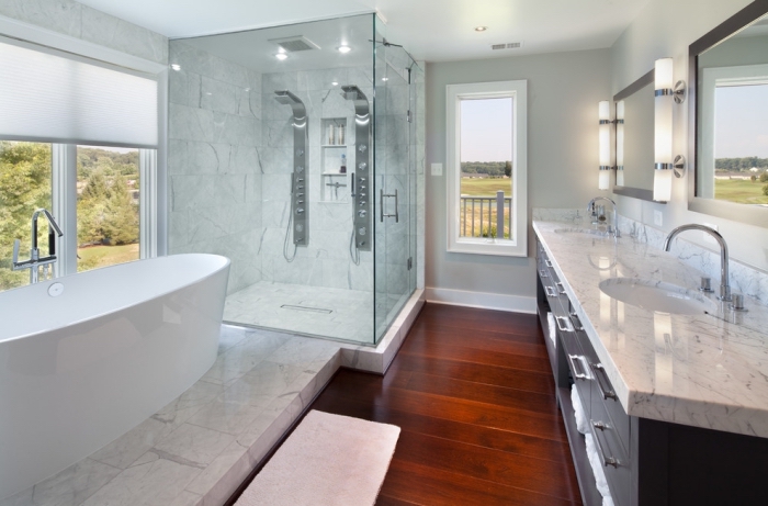 plancher salle de bain, carrelage à design blanc marbre et cabine de douche en verre, meubles de bain en bois noir et finitions métalliques