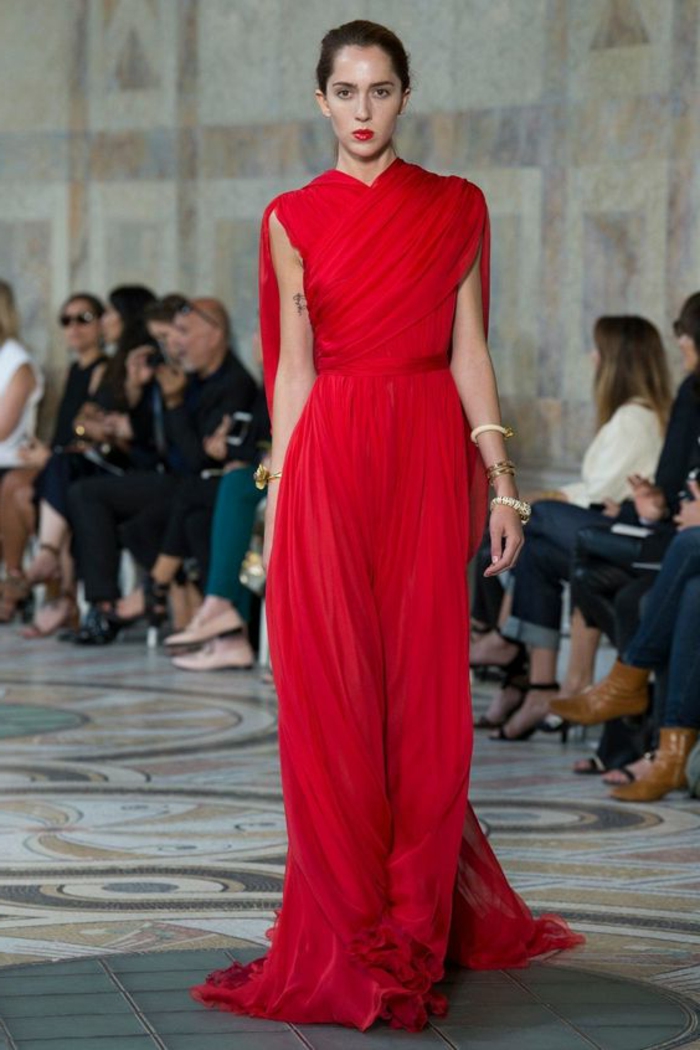 robe pour mariage rouge style déesse grecque, buste avec effet drapé, ceinture en tissu rouge, bracelets blancs sur les poignets 