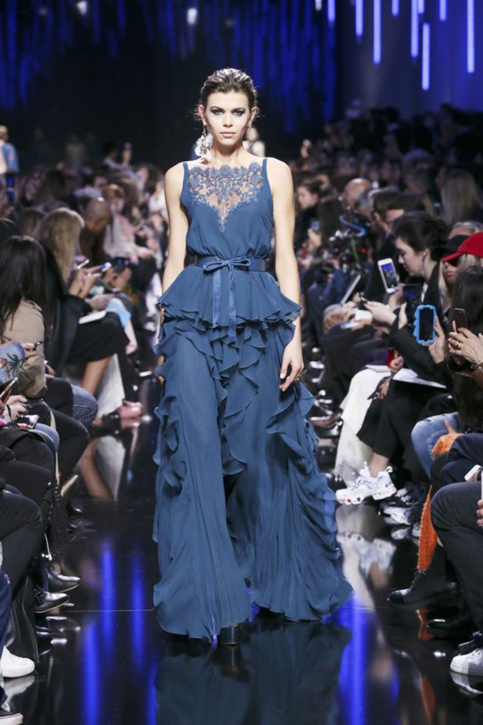 tenue de mariage femme en bleu indigo, volants tout au long de la jupe, zone du décolleté recouverte de dentelle bleue, ceinture en tissu, style vestimentaire Renaissance