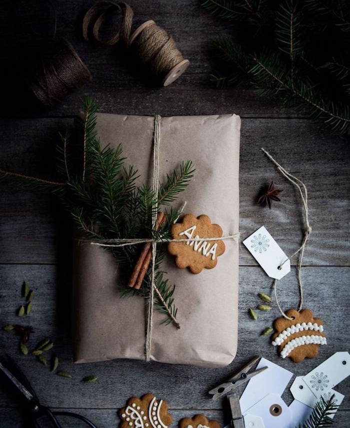 sachet kraft comem emballage cadeau, avec décoration de cannelle, branches de pin et sablé de noel en gingembre