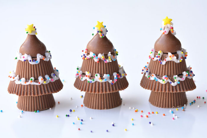 arbre de noel de bonbons au chocolat avec decoration glaçage blanc, petites billes colorées et étoiles jaunes de sucre