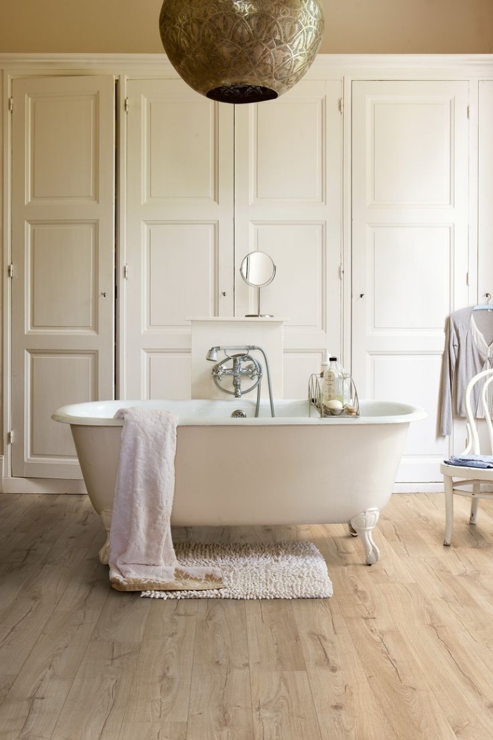 revetement salle de bain, modèle de baignoire blanche sur plancher en bois et tapis moelleux en blanc