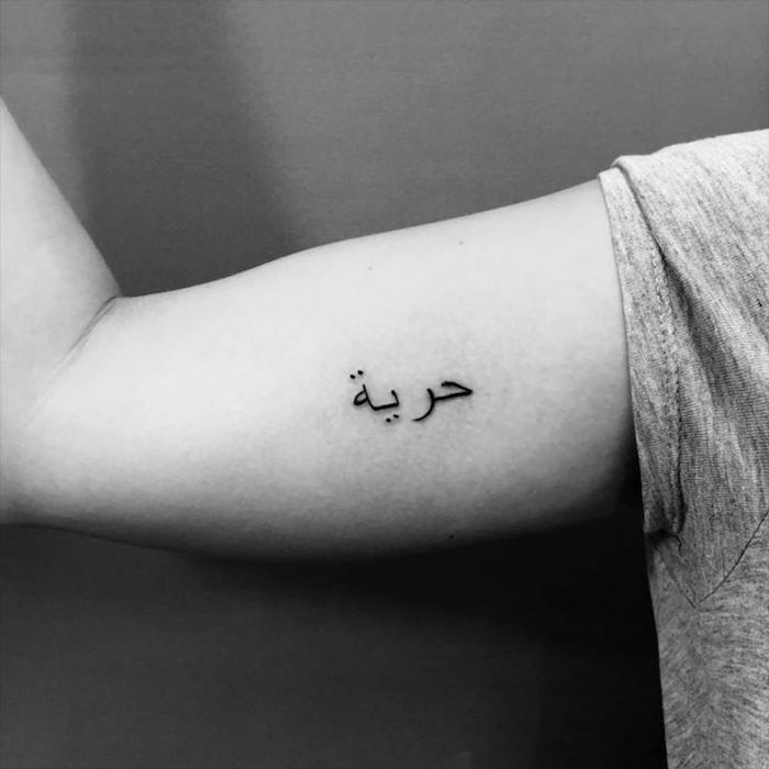 symbole liberté tatouage en arabe sur bras discret