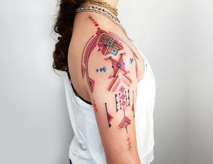 femme tatoué, dessin en couleurs sur l'épaule et le bras, art corporel aux motifs géométriques et flèches