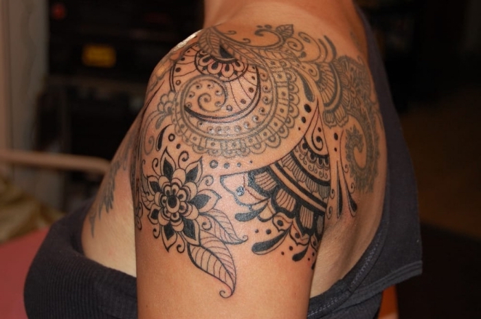 femme tatoué, dessin en encre sur épaule et dos à design fleurs et mandala ethniques