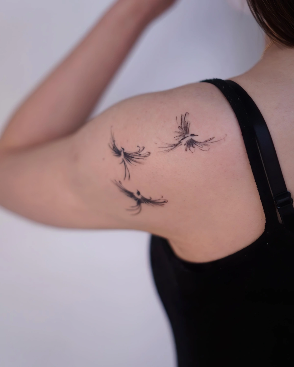 tatouage liberte oiseau dessin epaule femme vol debardeur noir