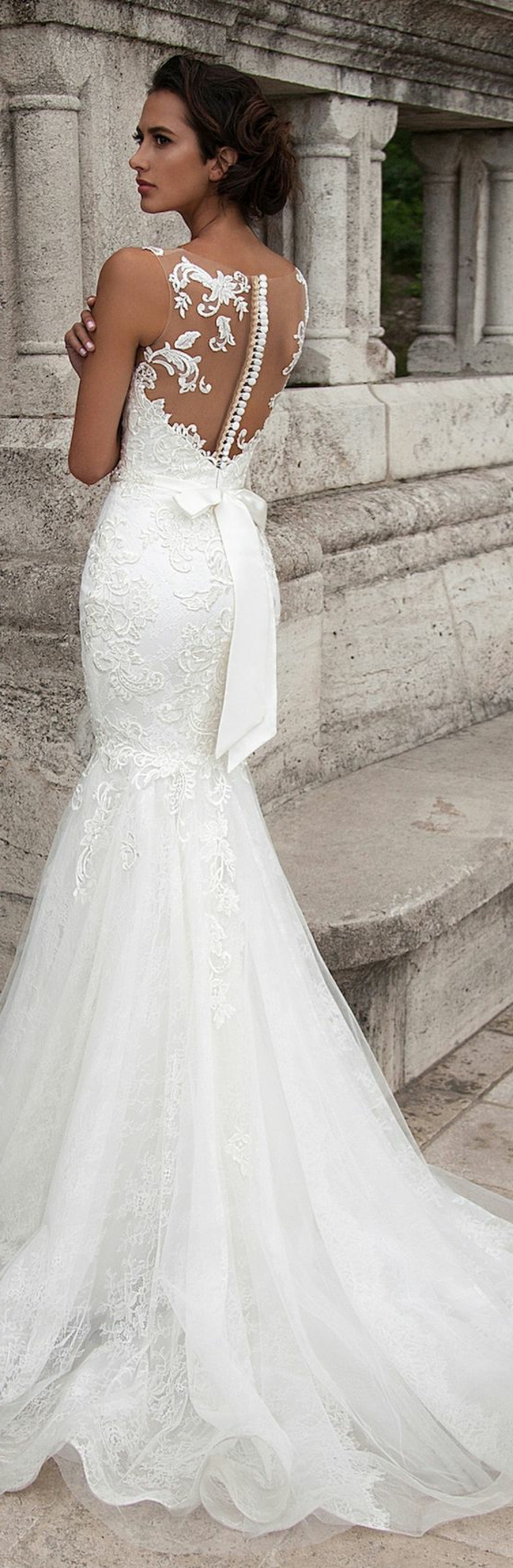 robe mariage civil en blanc, avec dos transparent et des boutons blancs, grand nœud papillon su la taille derrière, robe moulante qui se termine par une partie large en tulle blanc