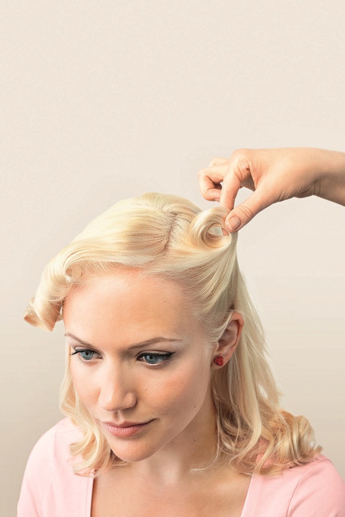 tuto pour réaliser une coiffure pin up facile avec des mèches torsadées relevées des deux côtés de la tête 