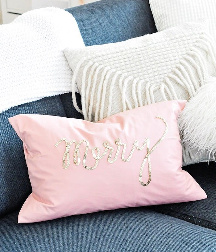 un coussin décoratif rose avec des paillettes dorées sur un canapé gris anthracite, cadeau de noel pour femme