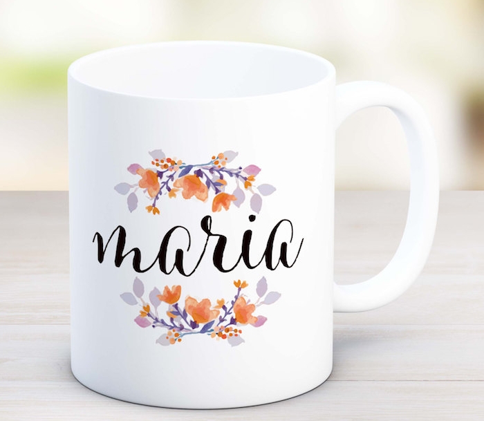 une tasse de café personnalisée blanche avec des branches fleuries et le prénom de la personne écrit dessus, idée cadeau maman pour noel