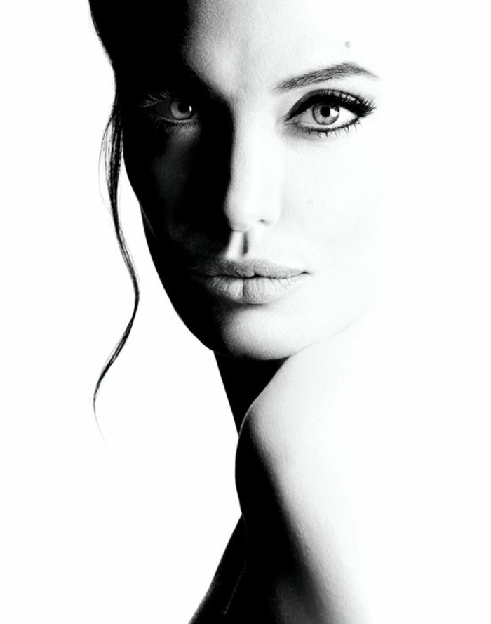 photo en noir et blanc, portrait bicolore d'Angelina Jolie, fixant des yeux, regard hypnotisant, beauté exceptionnelle 