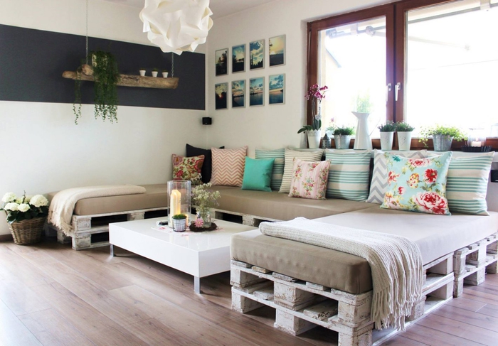 canapé d'angle en palette avec des coussins dépareillés en nuances pastel et motifs différents, meuble palette confortable et fonctionnel