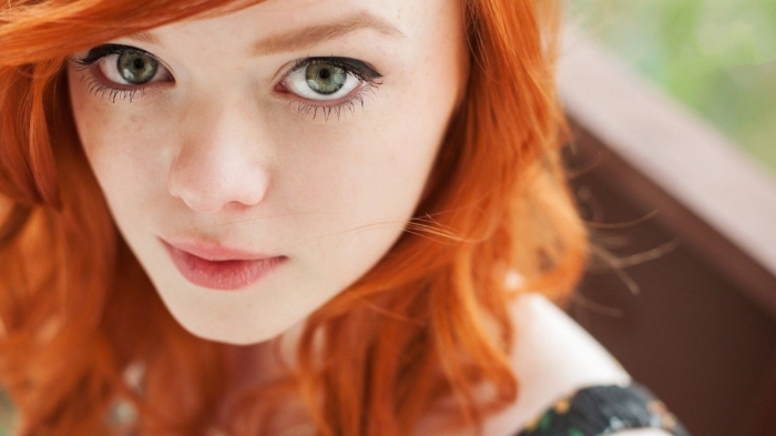 couleur cuivrée, jeune femme aux yeux verts et cheveux de coloration orange, maquillage pour yeux verts aux lèvres nude
