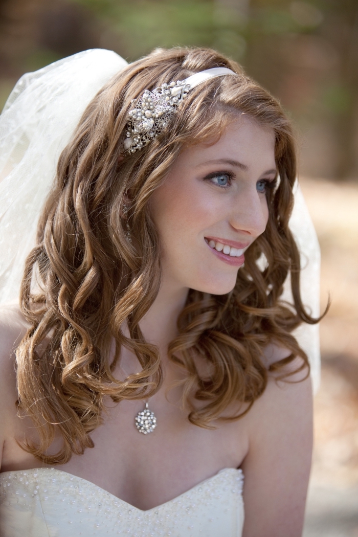 modèle de coiffure de mariée aux cheveux longs et bouclés de nuance châtain foncé avec diadème et voile