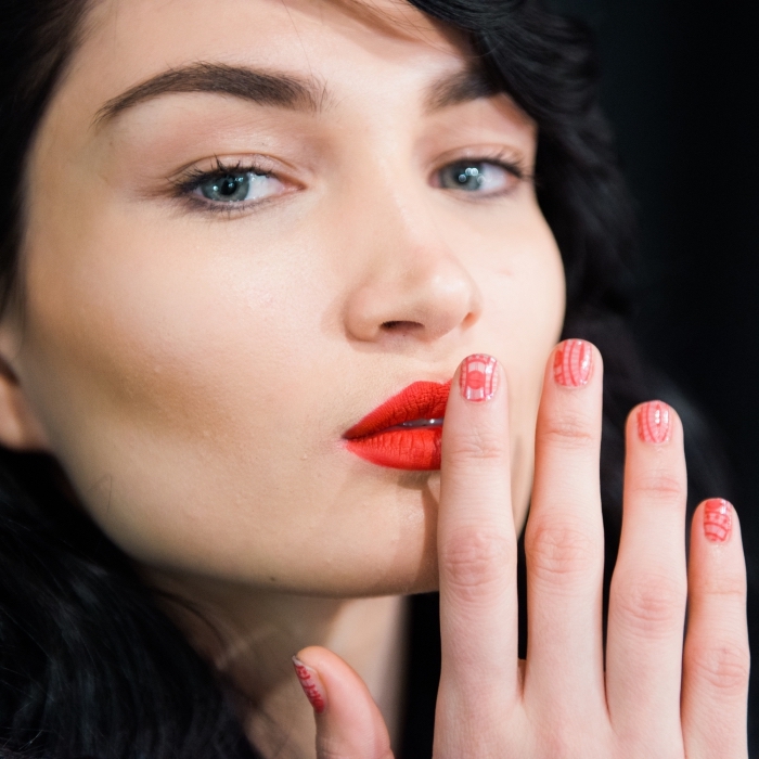 comment-choisir-son-rouge-à-lèvre-manucure-noel-rouge-yeux-bleus-maquillage-cheveux-noirs-frange-sur-le-côté comment se maquiller les yeux, femme aux cheveux noirs avec maquillage des yeux nude et lèvres rouges