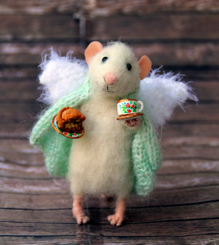 créer des sculptures en laine, une souris blanche amusante qui tient une tasse de café et un morceau de gateau