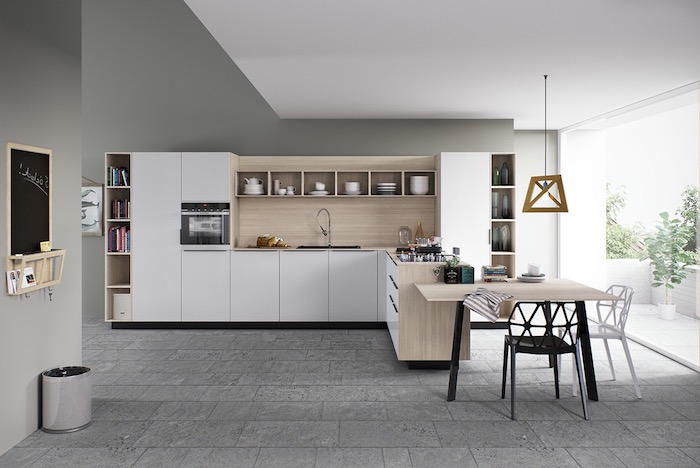 modele de cuisine amenage en blanc avec credence bois, table bois et chaises metal, revetement sol dalles en beton, murs gris
