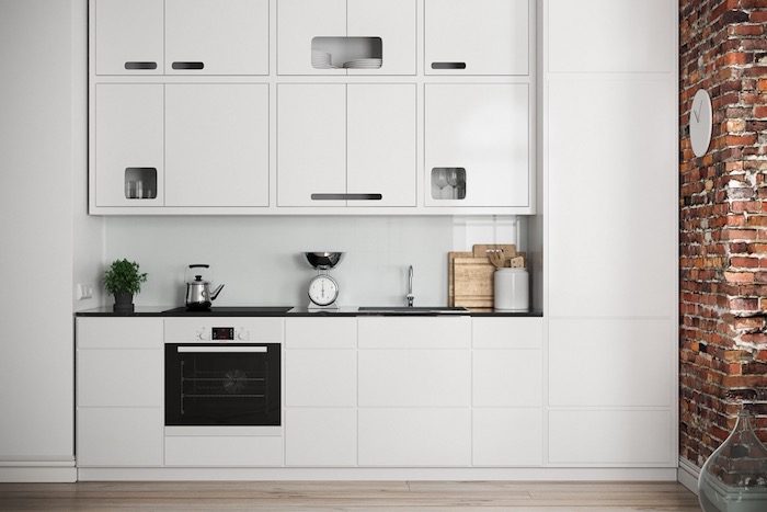 cuisine blanc laqué tout en blanc avec un four noir contrastant, mur en briques et parquet bois clair, design moderne industriel