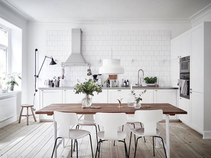 cuisine equipee en blanc avec une plan de travail gris, carrelage blanc, parquet clair, chaises blanches, aspirateur inox, style scandinave