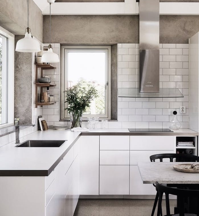 cuisine grise et blanche avec mur imitation beton, meuble cuisine blanc et plan de travail gris, aspirateur gris et verre, petite etagere d angle