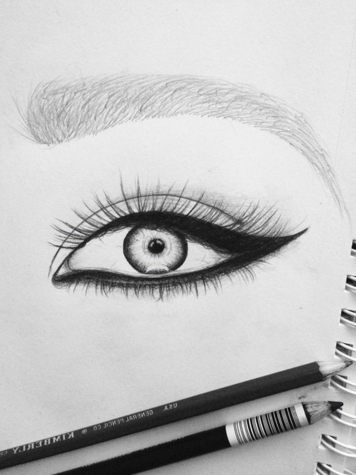 portrait noir et blanc, dessin femme noire, œil et sourcil hyper maquillé, crayons khôl sur la feuille du dessin, regard très expressif