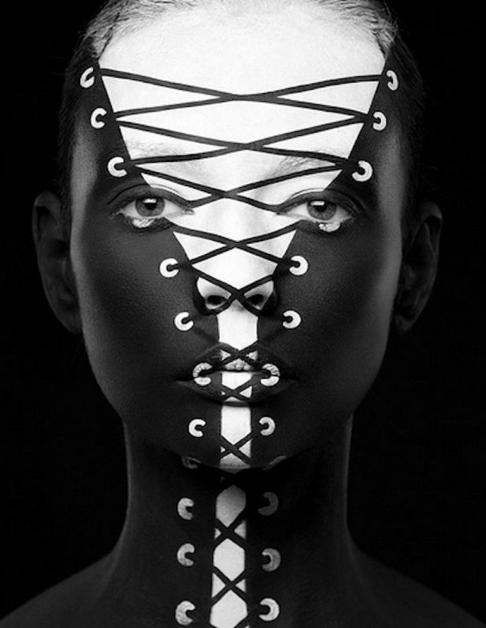 photo en noir et blanc, visage de femme caché dans un corsage qui s'ouvre, des yeux très expressifs, photo magazine de mode