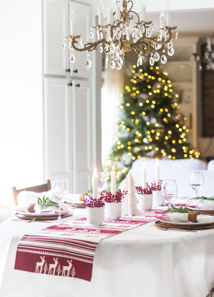 une table de noël rouge et blanc d'un style scandinave traditionnel avec son chemin de table aux motifs nordiques de saison 