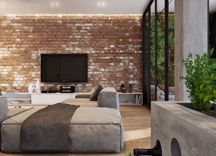 deco style industriel salon avec murs en briques, parquet bois clair, canapé gris, meuble tv blanc, verriere noire