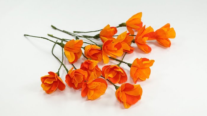 comment faire des fleurs en papier, exemple de fleurs couleur orange à grosses pétales et tiges vertes de fil de fer