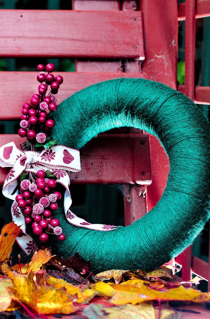 idées créatives pour une couronne de noel a faire soi meme, jolie couronne de noël revêtue de fil vert et décorée de fruits rouges artificiels