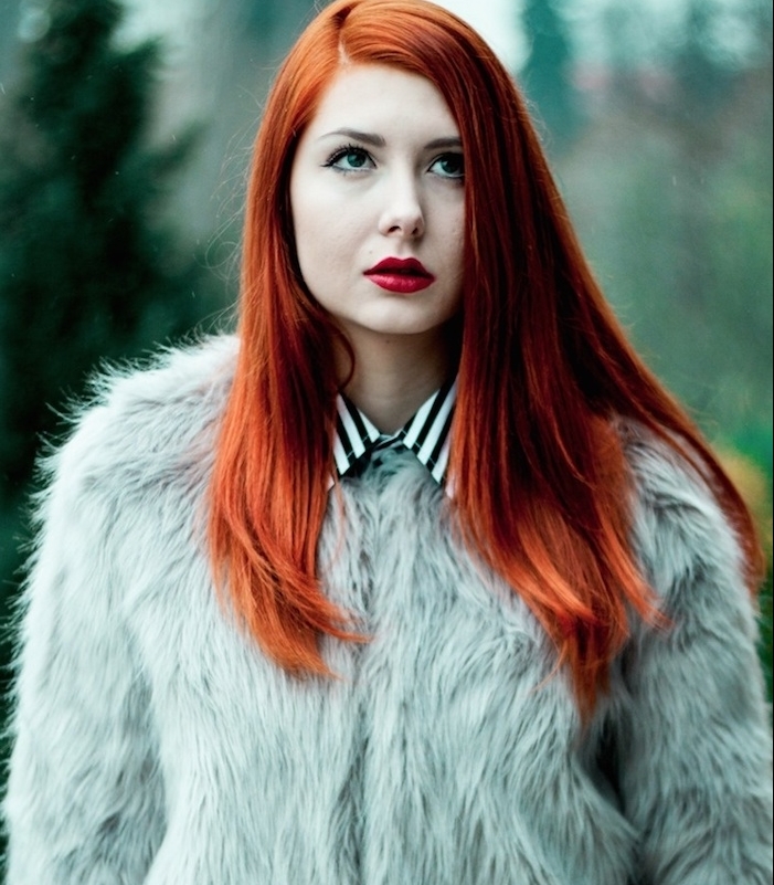 modele de cheveux cuivré avec des éclats roux et rouges, coiffure simple, cheveux lisses, blouson en peau animale