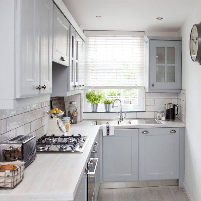 modele de petite cuisine équipée en l avec mobilier couleur grise, plan de travail bois clair, meubles hauts blancs, credence carrelage blanc