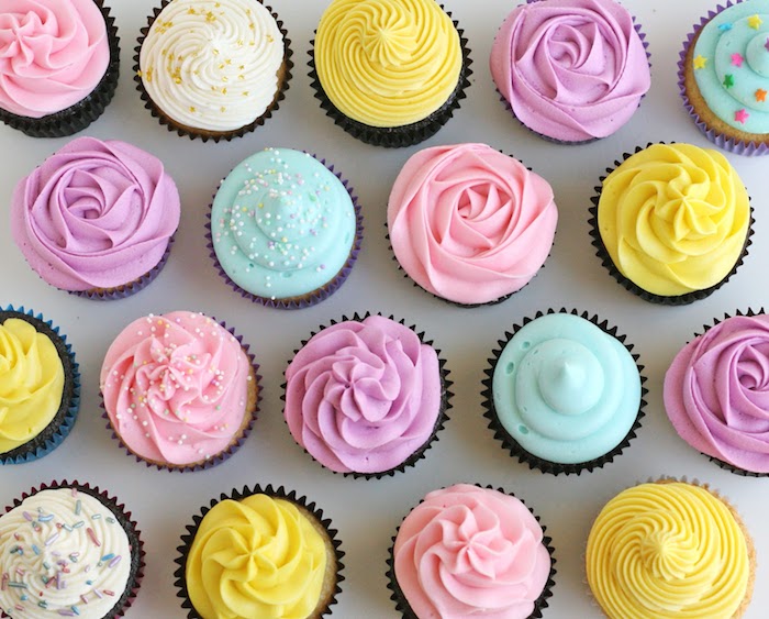 exemple de cupcakes avec glacage au beurre en forme de fleurs et décoration de zeste, billes et vermicelles colorés