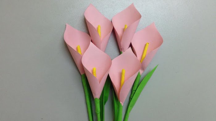 comment faire une fleur en papier rose, exemple de dahlias roses avec un centre jaune et feuilles vertes