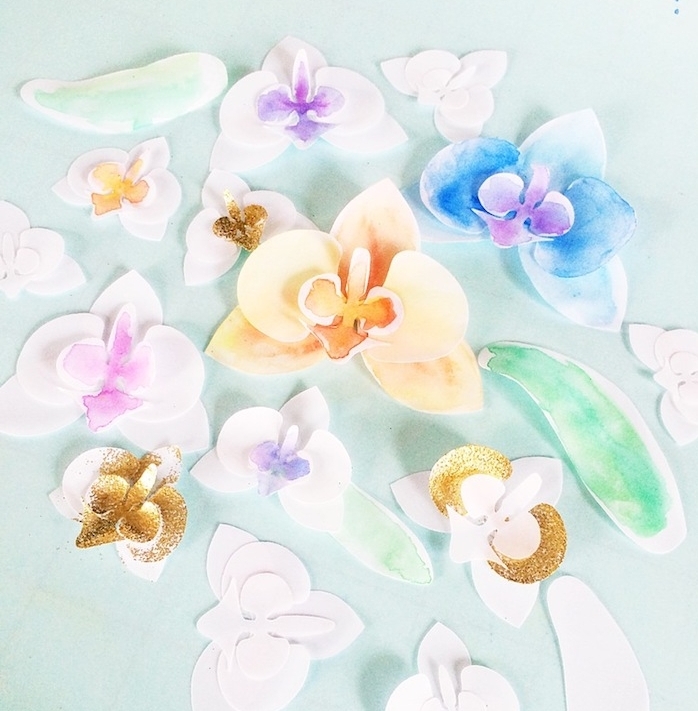des orchidées en papier, éléments divers en papier blanc décorés de peinture et paillettes, diy fleur en papier
