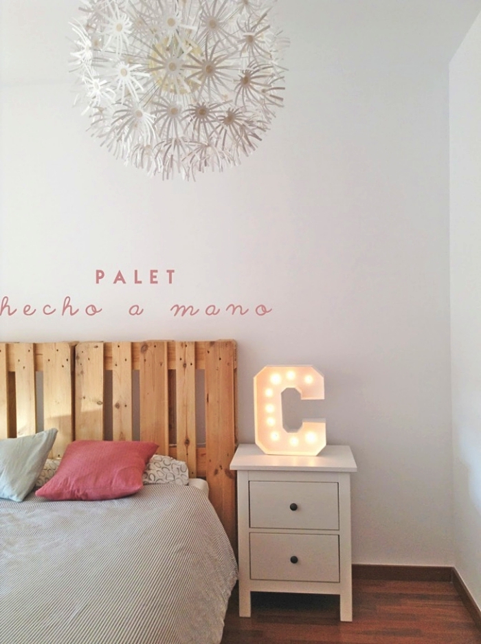 tete de lit en palette, chambre à coucher blanche avec parquet en bois et grand lit décoré de coussins rose et bleu