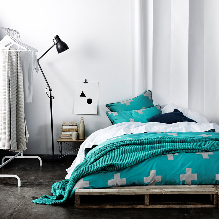 une chambre à coucher monochrome et minimaliste avec un lit palette bas 