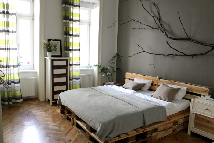 tete de lit en palette a faire soi meme, pièce aux murs gris et plancher de bois avec rideaux longs vert et marron