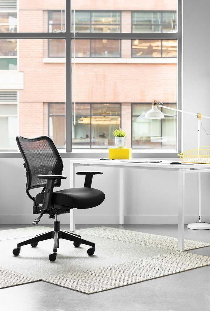 espace bureau minimaliste et élégant équipé avec un fauteuil de bureau à design ergonomique en tissu maille qui permet au corps de respirer