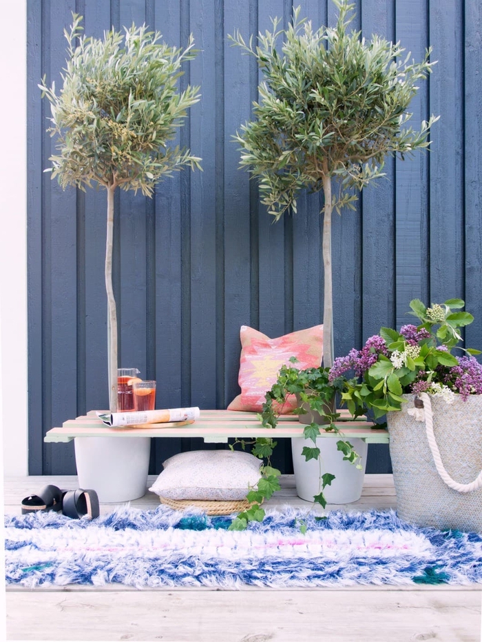 idée créative pour relooker la terrasse en créant un coin de repos avec banc palette posé entre deux arbres en pots