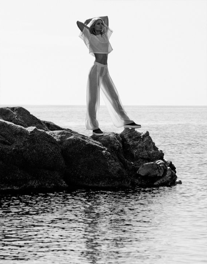 photo femme noir et blanc, femme qui contemple la mer sur un rocher dans l'eau, photo en noir et blanc, femme en tenue semi-transparente blanche, sexy et érotique