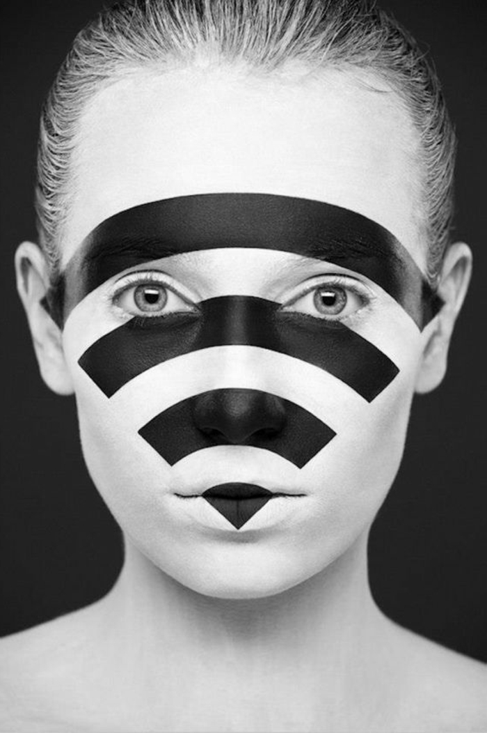photo noir et blanc, visage de femme avec symbole du wireless peint en noir sur sa peau, yeux grands ouverts