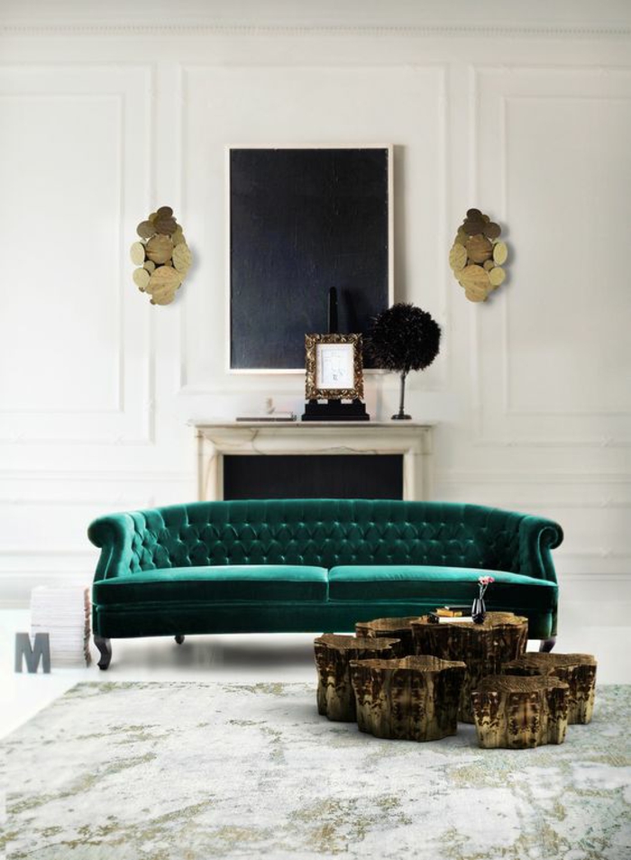 salon de luxe avec canapé en velours vert émeraude, deux appliques murales art déco en métal doré, avec abat-jours en forme de multiples cercles