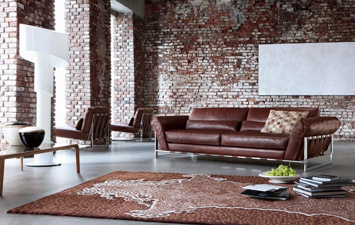 meuble style industriel avec canapé marron, tapis marron, sol béton, mur en briques, luminaire blanc