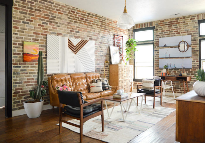 exemple de meubles style industriel dans un petit salon design, canapé en cuir marron, table basse en bois, chaises en bois et cuir, parquet marron, mur en briques