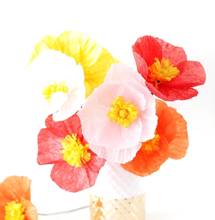 exempel de fleurs papier crepon rose, rouges er orange dans un vase blanc et or, jolie composition florale centre de table original