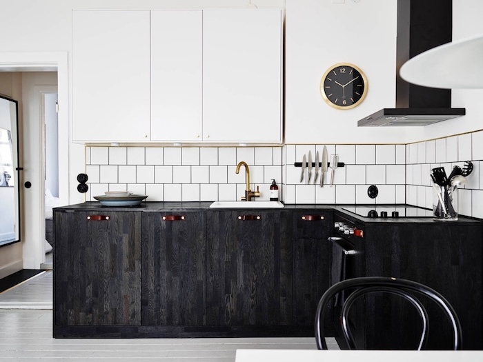 modele de petite cuisine équipée en bois foncé avec credence carrelage blanc retro, et meubles hauts blancs, aspirateur noir